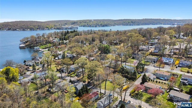 birds eye view of property featuring a wooded view, a residential view, and a water view