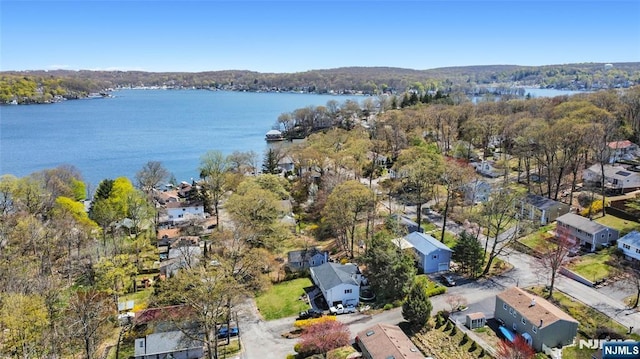 drone / aerial view featuring a residential view, a water view, and a view of trees