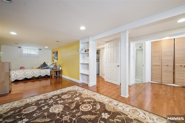 bedroom with baseboards, wood finished floors, and recessed lighting