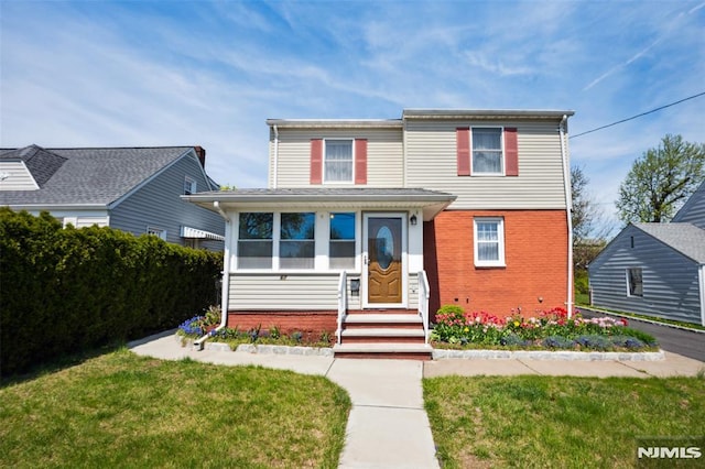 traditional home with brick siding and a front yard
