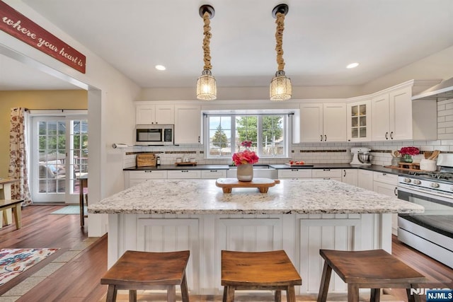 kitchen with white cabinetry, appliances with stainless steel finishes, decorative backsplash, and plenty of natural light