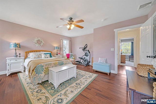 bedroom with dark wood-style flooring, visible vents, a ceiling fan, and baseboards