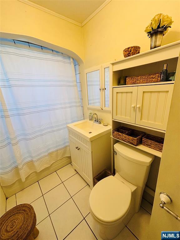 bathroom with a shower with shower curtain, toilet, ornamental molding, vanity, and tile patterned flooring