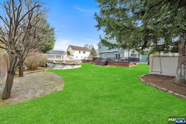 view of yard with an outdoor structure, a storage shed, a wooden deck, and a covered pool