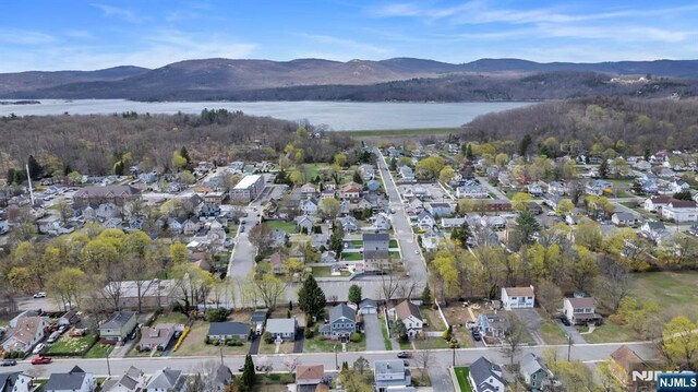 drone / aerial view featuring a residential view and a water and mountain view