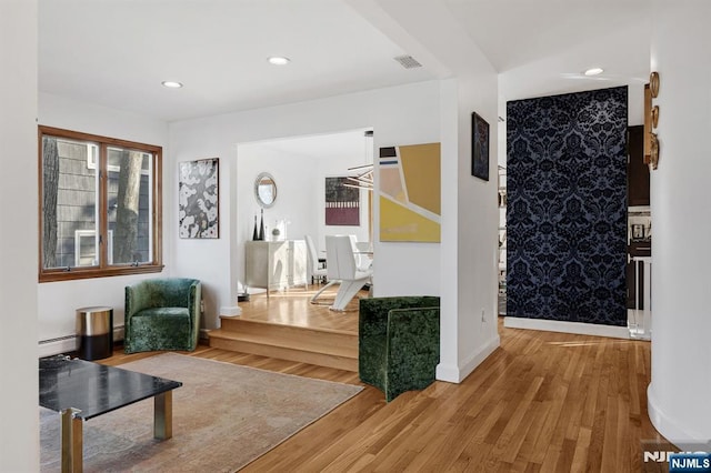 interior space with recessed lighting, wood finished floors, visible vents, a baseboard heating unit, and baseboards
