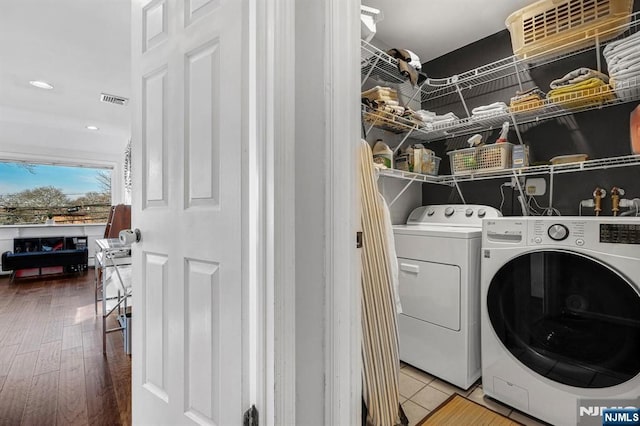 clothes washing area with washing machine and clothes dryer, wood finished floors, visible vents, laundry area, and recessed lighting