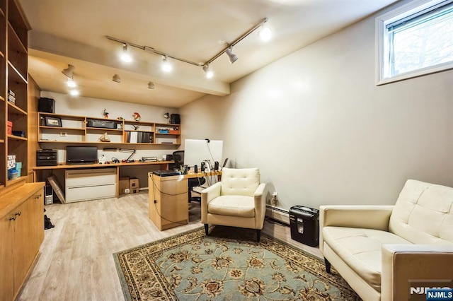 living area with light wood finished floors, built in study area, and rail lighting