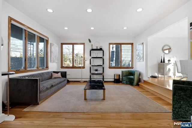 living area with recessed lighting, wood finished floors, baseboards, and a baseboard heating unit