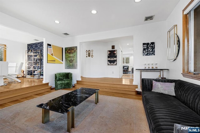 living room with recessed lighting, wood finished floors, visible vents, and baseboards