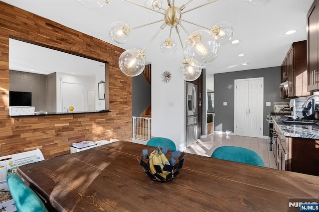 dining area with wood walls, baseboards, and light tile patterned floors