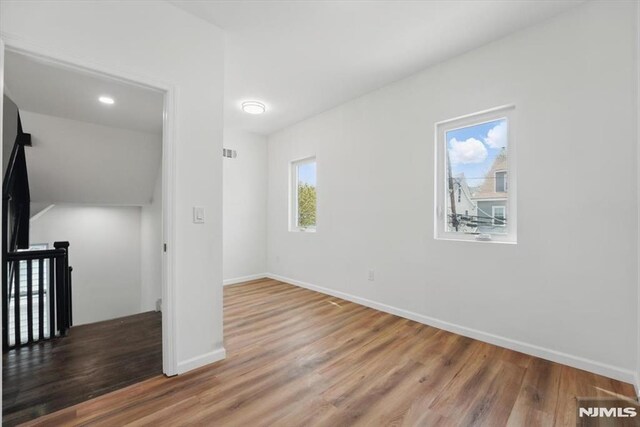 interior space with visible vents, baseboards, and wood finished floors