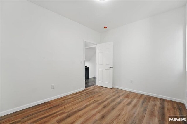 empty room with wood finished floors and baseboards