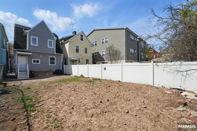 view of yard with central air condition unit and fence