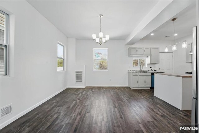 kitchen featuring light countertops, visible vents, dark wood-type flooring, baseboards, and a chandelier