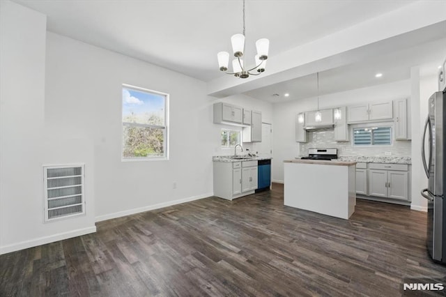 kitchen featuring stainless steel appliances, dark wood-style floors, a sink, visible vents, and a chandelier