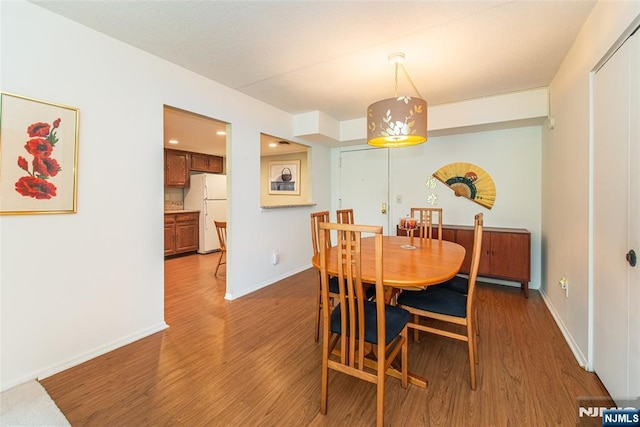 dining area with wood finished floors and baseboards