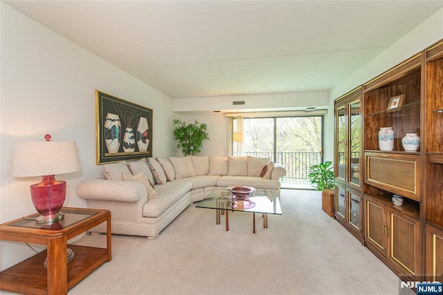 living area featuring visible vents and carpet flooring