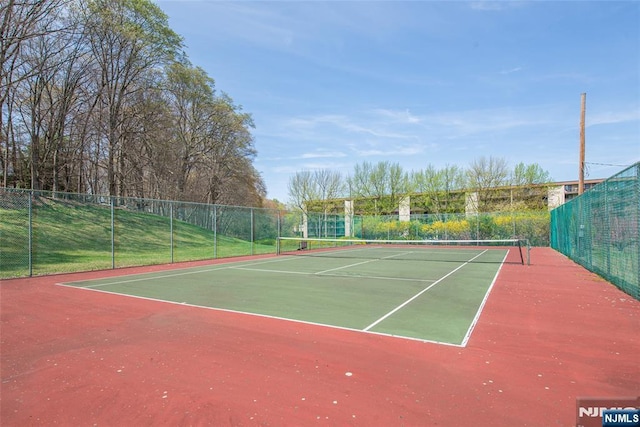 view of tennis court featuring fence
