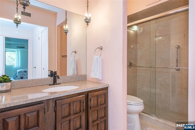 bathroom with visible vents, vanity, a shower stall, and toilet