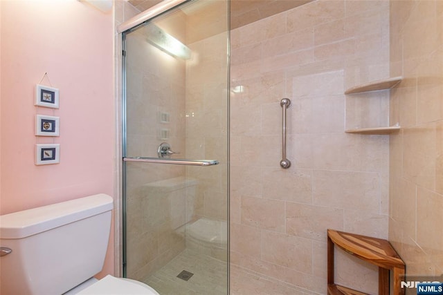 bathroom featuring a tile shower and toilet