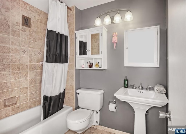 bathroom with shower / bath combo with shower curtain, toilet, and tile patterned flooring