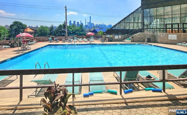 community pool featuring a patio area and fence