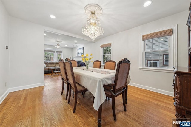 dining space featuring recessed lighting, light wood-style flooring, baseboards, and an inviting chandelier