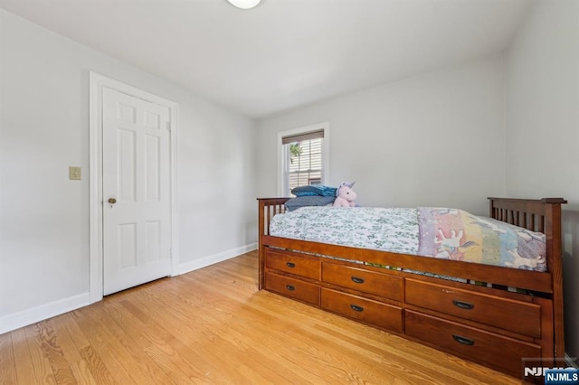 bedroom with light wood finished floors and baseboards