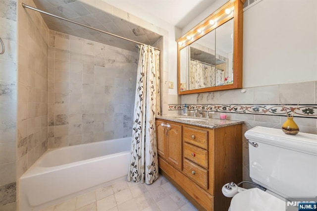 bathroom featuring shower / bath combo, toilet, vanity, and tile walls