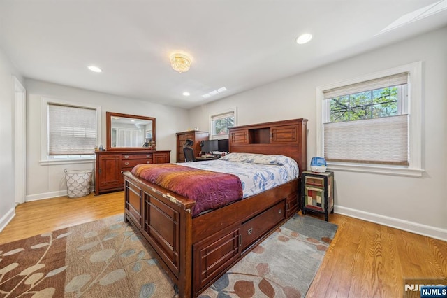 bedroom featuring recessed lighting, light wood-type flooring, baseboards, and multiple windows
