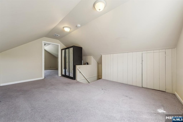 additional living space featuring lofted ceiling, baseboards, carpet, and visible vents
