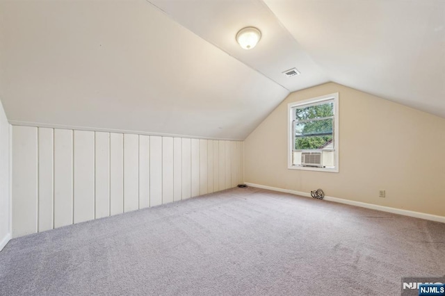 additional living space with vaulted ceiling, carpet floors, visible vents, and baseboards