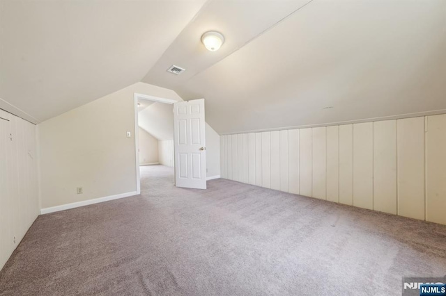 bonus room featuring baseboards, vaulted ceiling, and carpet flooring