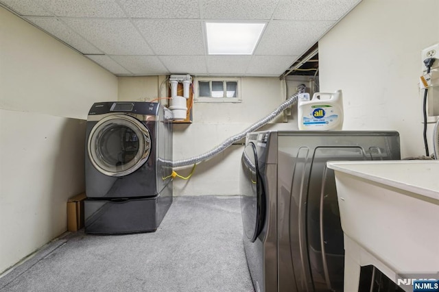 laundry area with washing machine and clothes dryer, a sink, carpet, and laundry area