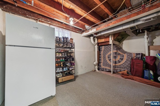 basement with freestanding refrigerator and carpet flooring