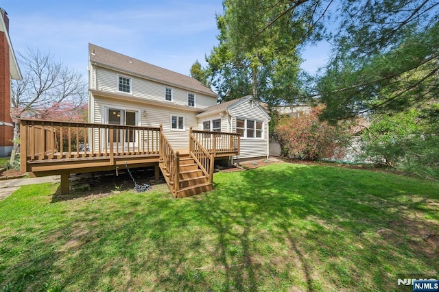 back of house featuring a wooden deck and a lawn