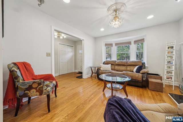 living area with recessed lighting, light wood-style floors, and an inviting chandelier
