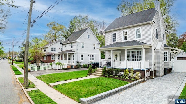 view of front of home featuring fence, covered porch, a chimney, and a front yard