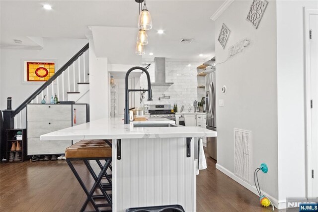 kitchen featuring visible vents, wall chimney exhaust hood, dark wood-style flooring, and backsplash