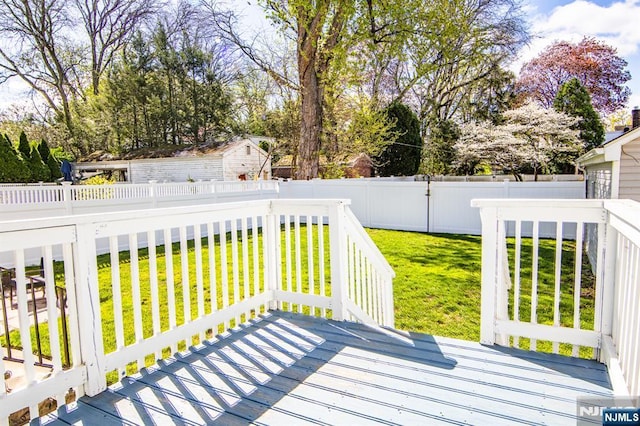 deck featuring a lawn and a fenced backyard