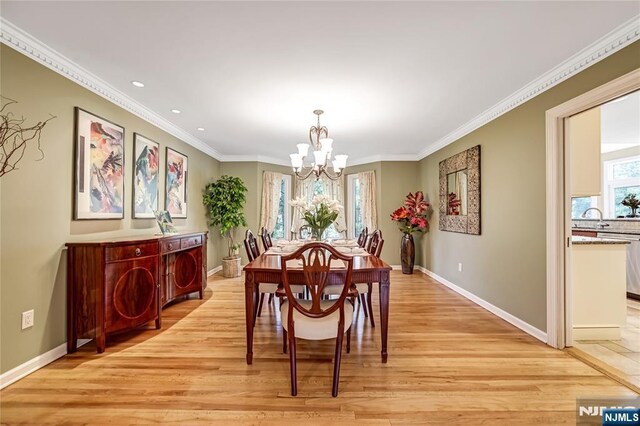 dining room with baseboards, recessed lighting, an inviting chandelier, light wood-style floors, and ornamental molding