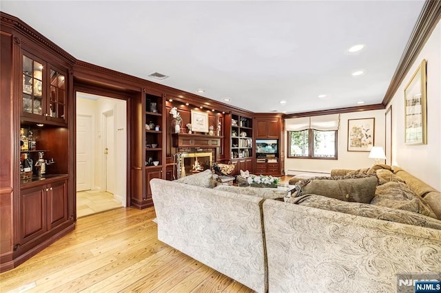 living room featuring a baseboard radiator, light wood finished floors, ornamental molding, visible vents, and recessed lighting