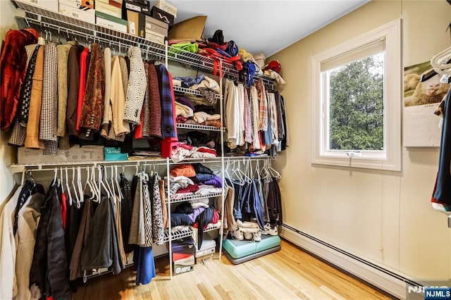 walk in closet with baseboard heating and wood finished floors