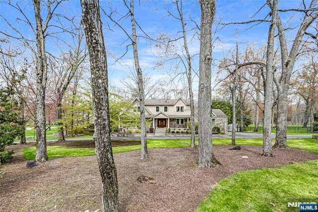 view of front of property featuring a porch and curved driveway