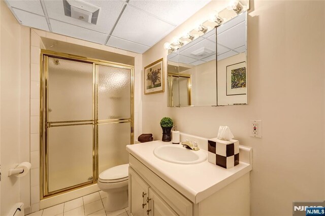 bathroom with a paneled ceiling, toilet, visible vents, a shower stall, and vanity