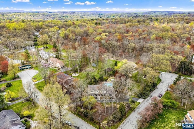 bird's eye view with a wooded view