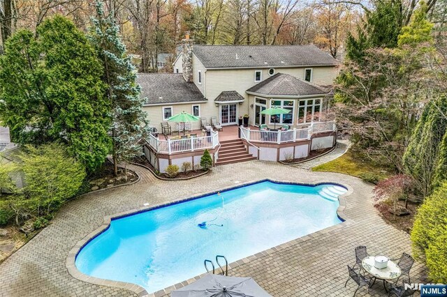 pool featuring a patio area, stairway, and a deck
