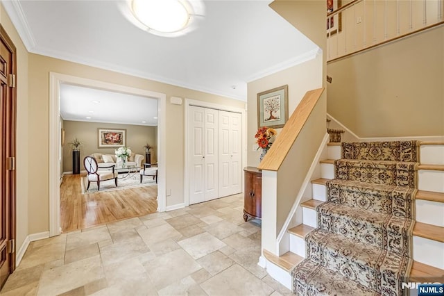 foyer featuring stairway, stone finish flooring, baseboards, and ornamental molding