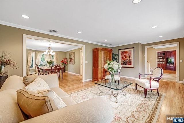 living room featuring light wood finished floors, visible vents, recessed lighting, and a notable chandelier